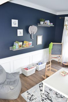 a living room with blue walls and white trim on the walls is filled with toys