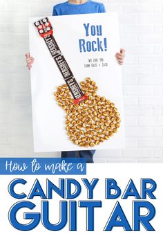 a kid holding up a candy bar guitar sign with the words how to make a candy bar guitar