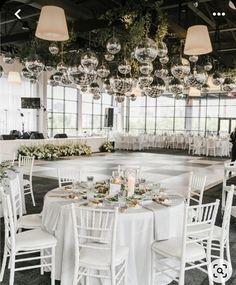 a room filled with lots of white tables and chairs