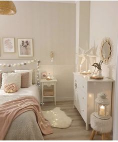 a bedroom with white furniture and lights on the wall above the bed is decorated in pastel tones