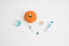 an orange sitting on top of a white table next to some other items and utensils