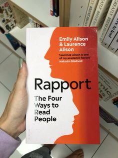 a person holding up a book about rapport