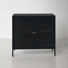 a black cabinet sitting on top of a floor next to a white wall with two doors