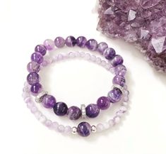 "Amethyst Gemstone Bracelet Set Of Two As a master healer and powerful protection crystal, Amethyst is known as the \"stone of calm.\" This purple beauty emits calming vibrations which help soothe the body, mind, soul and spirit.  Wearing an amethyst bracelet s a lovely way to carry tranquil energy around with you wherever you go.  Features: * Amethyst 8mm * Amethyst 4mm * 925 Sterling Silver bead spacers 4mm * Crystal Pave silver spacers 8mm * Strong Stretch Cord * This is a stretch Amethyst br Amethyst Bracelet Gemstones, Light Purple Bracelet, Gemstone Bracelets Ideas Trendy, Purple Bead Bracelet Ideas, Elegant Stone Bracelet, Beaded Crystal Bracelet, Amethyst Stone Bracelet, Purple Bracelet Ideas, Bracelet Set Ideas