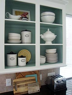 the shelves in the kitchen are filled with dishes