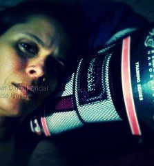 a woman with her hand on her face holding a large object in front of her head