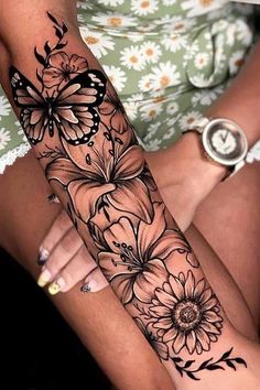 a woman's arm with flowers and butterflies on it