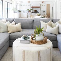 a living room filled with lots of furniture and pillows on top of a ottoman next to a coffee table