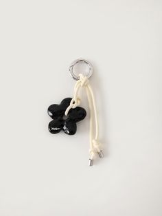 a black and white keychain with two keys attached to it on a white surface