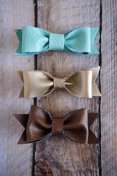 three different bows are on top of each other, one is brown and the other is teal