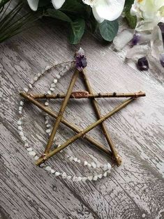 a wooden pen with beads around it and a star ornament next to flowers