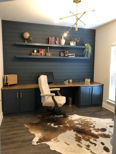 a home office with cow hide rug and shelves