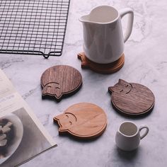 four wooden coasters sitting on top of a table next to a cup and book