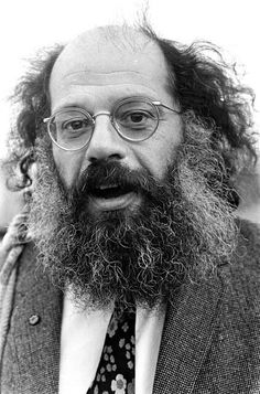 a black and white photo of a man with a long beard wearing glasses, a tie and a suit jacket