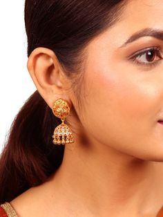 This traditional Disha Jhumka is a testament to intricate design and meticulous craftsmanship. Its stud section boasts a graceful peacock motif, Jhumka is adorned with the exquisite allure of white zircon stones. The addition of delicate ball dangles enhances the beauty of this Jhumka. Crafted from 925 silver and polished to a lustrous gold finish. Please refer to the pictures of the jewelry worn on a model to get a clear idea of the size. Condition: New. This product is intricately designed and Traditional Gold Cubic Zirconia Jhumkas, Gold Ceremonial Jhumkas, Gold-plated Fusion Jhumkas, Hand-set Cubic Zirconia Jhumkas For Celebrations, Traditional Ceremonial Intricate Jhumkas, Traditional Jhumka, Peacock Motif, Stamped Earrings, Silver Wedding Jewelry