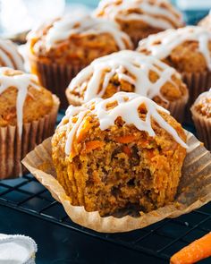 carrot muffins with icing sitting on a cooling rack