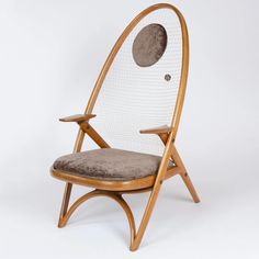 a wooden chair with a cushion on the seat and a circular back rest in front of it