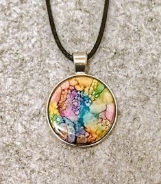 This really great confetti style pendant was created using vivid inks that meld and blend into these interesting designs. This necklace would be a wonderful accent to most outfits and surely noticed. Its setting is surgical steel and is non tarnish and hypoallergenic.Its finished with a very thick coat of resin to make it durable and protect the colors.Also included is a pendant cord with a adjustable chain,a description card and a gold satin gift poach Alcohol Ink Jewelry, Colored Jewelry, Wearable Art Jewelry, Jewelry Candles, Jewelry Resin, Gold Satin, Long Dangle Earrings, Colorful Jewelry, Cool Jewelry