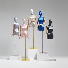 four mannequins on display in different colors and sizes, all standing upright