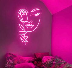 a neon pink room with a bed, pillows and a rose on the headboard