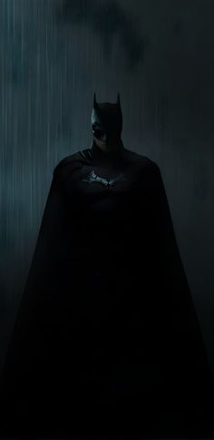 a batman standing in the rain at night