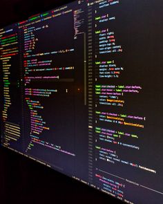 a computer screen with multiple lines of code on it's display wall in a dark room