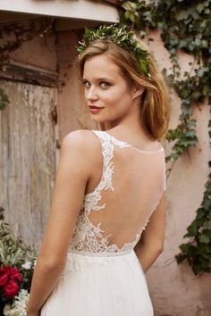 a woman in a wedding dress with flowers on her head