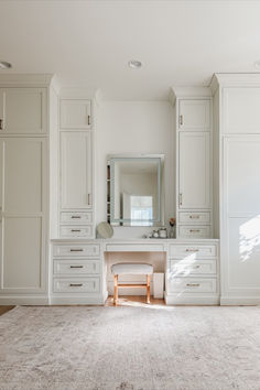 a large white bathroom with lots of cabinets