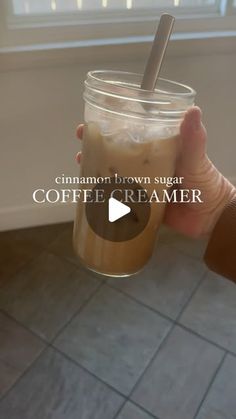 a person holding a cup with a straw in it and the caption cinnamon brown sugar coffee creamer