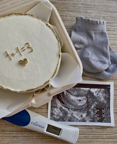 a birth cake in a box next to a pair of socks and a thermometer