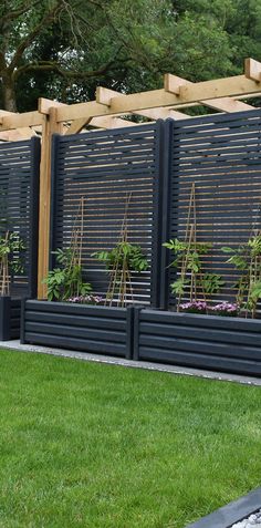 a row of wooden planters in front of a fence