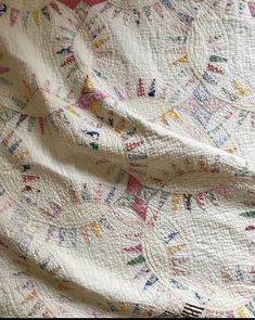 a white quilt with colorful designs on it