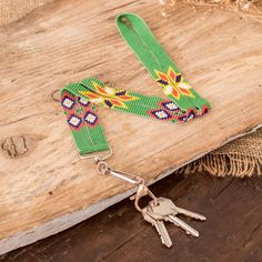 a keychain with two keys attached to it on top of a wooden board