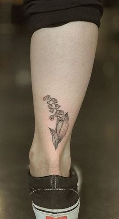 a woman's foot with a small flower tattoo on her left side calfocks