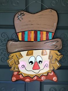 a close up of a wooden sign with a clown face