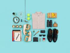 an assortment of personal items laid out on a blue background, including shoes and accessories