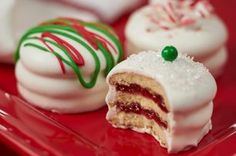 several desserts on a red plate with white and green frosting, one half eaten