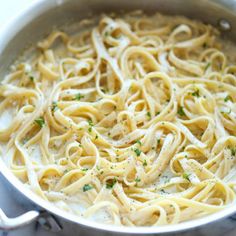 a pan filled with pasta and parsley on top of a stove