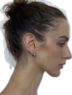 a woman's profile with her hair in a bun and earrings on the ear