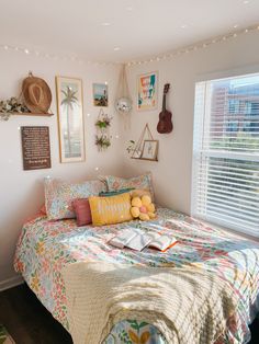 a bed room with a neatly made bed and lots of pictures on the wall above it