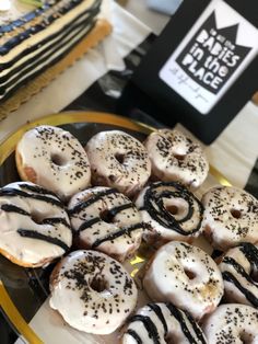 there are many donuts on the plate with black and white icing, along with other pastries