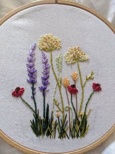 a close up of a embroidery on a piece of cloth with flowers in the middle