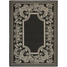 a black and white rug with an ornate border on the bottom, surrounded by flowers