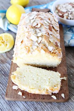 a loaf of lemon almond bread sitting on top of a wooden cutting board