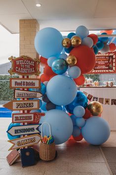 a bunch of balloons that are on top of a sign post in front of a building