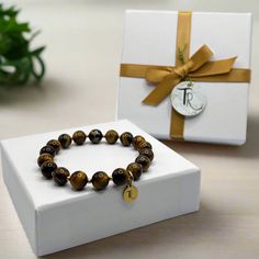 Unleash your inner tiger (or at least your fierce fashion sense) with this Tiger's Eye beaded stretch bracelet. Stretchy, comfortable, and undeniably stylish, it's the perfect accent piece for any outfit. Show off your wild side and add a touch of fun to your wardrobe with this trendy bracelet. Pounce on it before it's gone! Length: 6.5", 16.5cm - Fits small to medium wrists Jeweler's stretch cord - For a comfortable, adjustable fit Gold plated brass accents - To compliment the beads and add texture 8mm TIger's Eye beads - For happiness, calm, and confidence Handmade by Tammy - For quality and original design This product has been handmade by Tammy in Lincoln, Nebraska.T. Randall Jewelry is a woman owned jewelry brand that features handmade and curated pieces. Trendy Stretch Bracelet With 8mm Beads As Gift, Trendy Stretch Bracelet With 8mm Beads For Gifts, Trendy 8mm Beads Stretch Bracelet Gift, Brown Stretch Bracelet With Letter Beads As Gift, Tiger Bracelets, Tigers Eye Bracelet Men, Tigers Eye Beaded Bracelet, Trendy Bracelet, Tiger Stone Bracelet