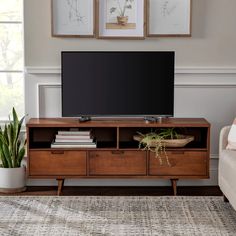 a flat screen tv sitting on top of a wooden entertainment center