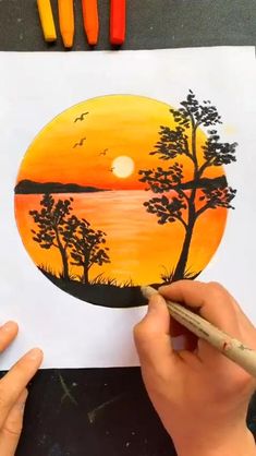 someone is drawing a sunset scene with crayons