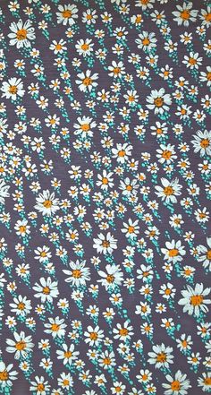 a blue and yellow flowered fabric with small white daisies on the top of it