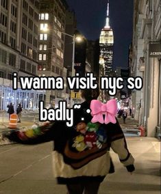 a woman walking down the street with a pink bow on her back and text that reads i wanna visit nyc so badly